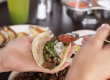 person eating mexican food, tacos with fresh ingredients and salsa | Guadalajara Mexican Grill in Panama City Beach, Florida offers authenic mexican food for lunch & dinner, happy hour specials, margaritas, & winter specials.